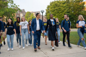 Santa J. Ono walks on the Diag with students.