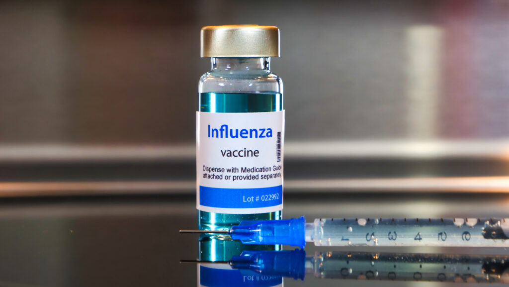 Vial of influenza vaccine and syringe. Image credit: iStock