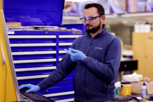 Abdul Khan prepares to weld a sample of plastic and metal. Image credit: Brenda Ahearn, College of Engineering