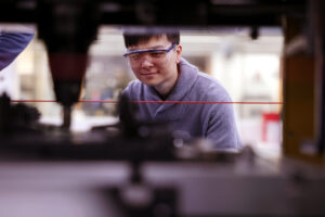 Yuning Zhang prepares to weld a sample of plastic and metal. Image credit: Brenda Ahearn, College of Engineering