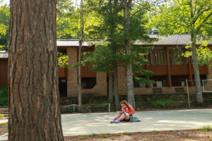 Student sits on the volleyball court at U-M's Biiological Station.