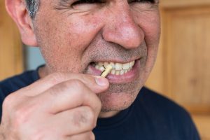 U-M School of Dentistry teacher Carlos Gonzalez demonstrates an improvised Kenyan toothbrush.