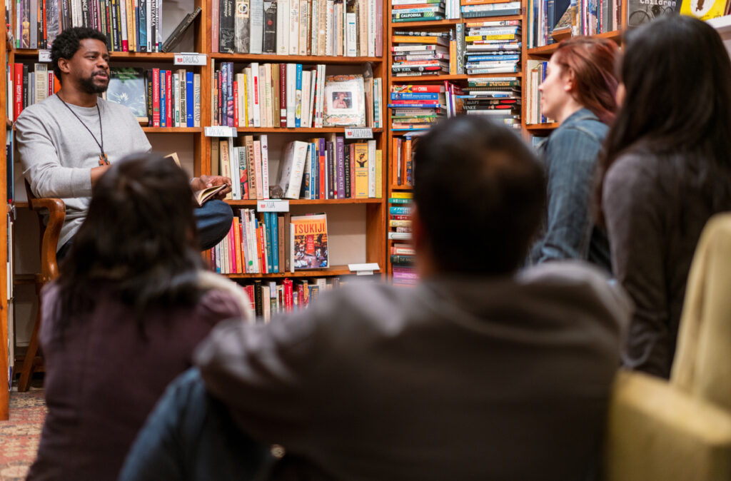 A man reads to a group, meeting in an independent bookstore. Image credit: iStock