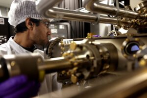 Ishtiaque Ahmed Navid, a doctoral student in electrical and computer engineering, operates the molecular beam epitaxy device in which he grew the semiconductor that harnesses sunlight to split water. Image credit: Brenda Ahearn/Michigan Engineering, Communications and Marketing