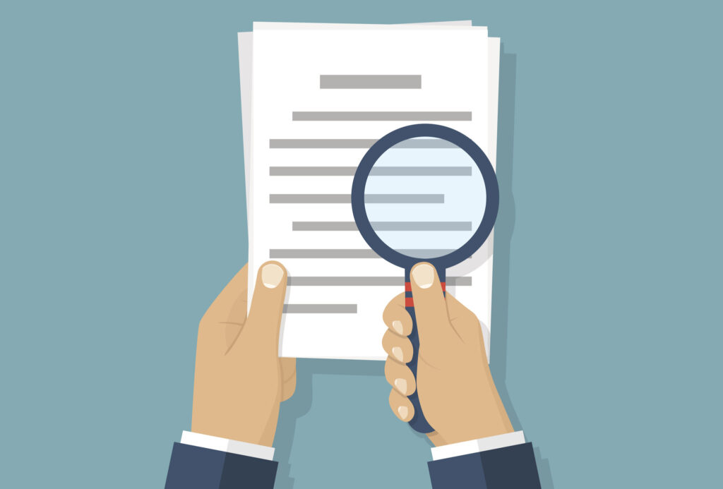 Magnifier and paper document. Image credit: iStock