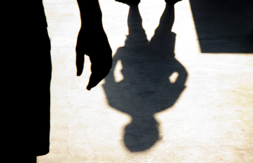 Blurry shadow silhouette of two boys confronting each other in school yard, Image credit: iStock