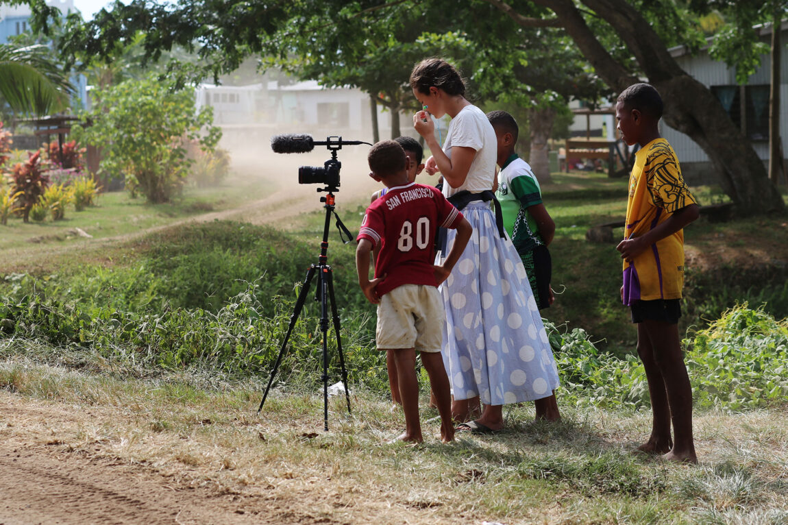 Photo of Ellie Schmidt behind a camera with four boys