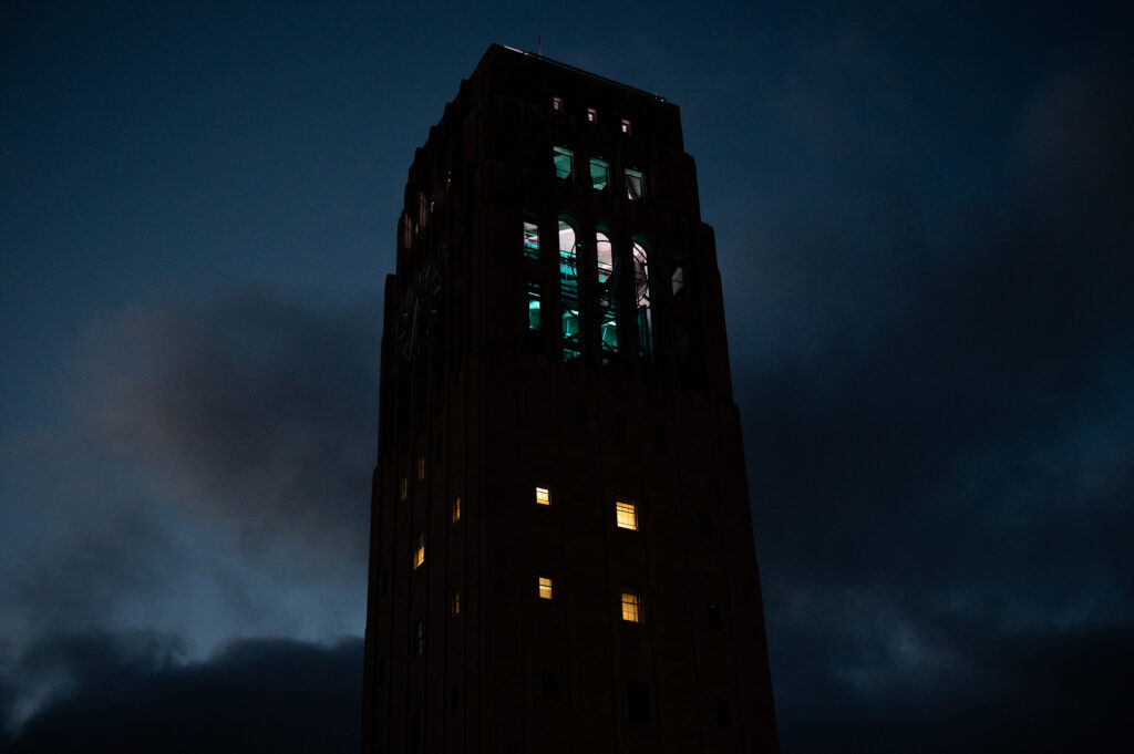 The Burton Tower turns green and white as the University of Michigan community mourns the Michigan State University students who were killed and injured during a mass shooting earlier this week on Wednesday, Feb. 15, 2023.