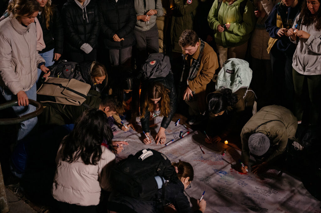 The University of Michigan community signs a banner that will later be given to Michigan State University during a vigil to mourn the Michigan State University students who were killed and injured during a mass shooting earlier this week on Wednesday, Feb. 15, 2023.