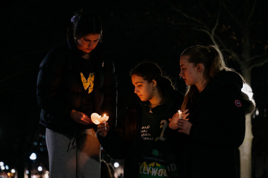 From left, LSA sophomore Kaylee McClellan, 19, Kinesiology sophomore Dayssi Phills, 19, and LSA sophomore Ava Douglas, 19, light candles during a vigil mourning the Michigan State University students who were killed and injured during a mass shooting earlier this week on Wednesday, Feb. 15, 2023.