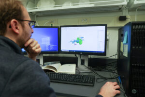 University of Michigan paleontologist Matt Friedman examines CT scan images of an exceptionally preserved, 319-million-year-old fossilized fish brain. Pulled from a coal mine in England more than a century ago, the fossil is the oldest example of a well-preserved vertebrate brain. Photo credit: Jeremy Marble, University of Michigan News.
