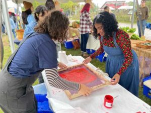 Assisting the screen printing station during HarvestFest 2022. Image credit: Chase Dautrich