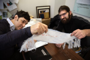 Chemical Engineering Professor Max Stein and Brian Iezzi, Post-doctoral Researcher at Materials Science and Engineering Department analyze the fabric with photonic fibers woven into it at the University of Michigan’s North Campus Research Center in Ann Arbor, MI. Image credit: Marcin Szczepanski/Lead Multimedia Storyteller, University of Michigan College of Engineering