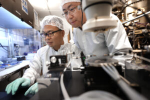 Research scientists Ding Wang (left) and Ping Wang (right) check the ferroelectricity of a sample of the semiconductor, which can now be made just 50 atoms thick. This next-generation material now has the potential to be integrated with conventional computing devices. Image credit: Brenda Ahearn.