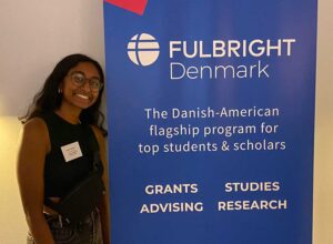 Neha Allathur poses with a Fulbright Denmark sign.