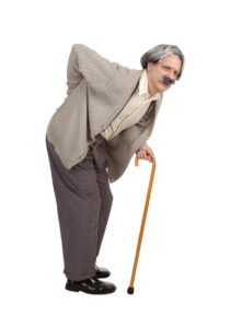 A man hunched over with a cane, having back pain