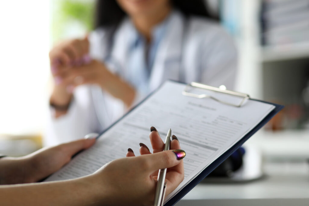 Visitor filling out medical documents. Image credit: iStock
