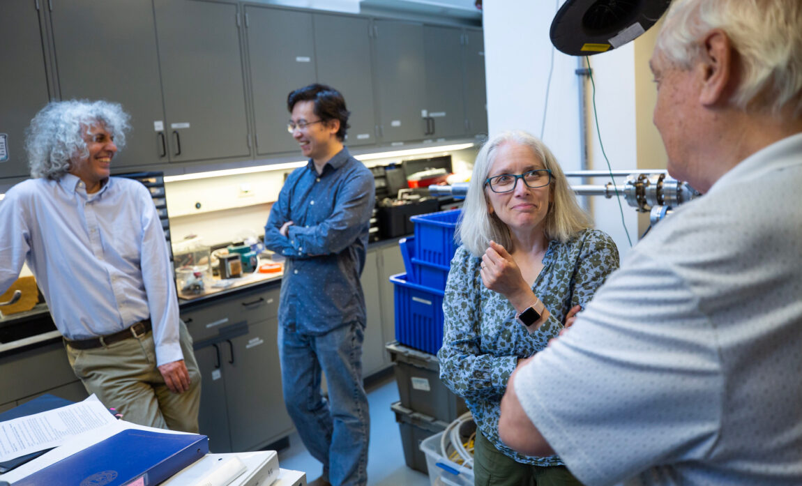 From left, Cagliyan Kurdak, professor of physics, Kai Sun, professor of physics, Rachel Goldman, professor of materials science and engineering, and Ctirad Uher, the C. Wilbur Peters Collegiate Professor of Physics, chat in the Goldman Group Molecular Beam Epitaxy Laboratory. (Photo by Evan Dougherty, College of Engineering)