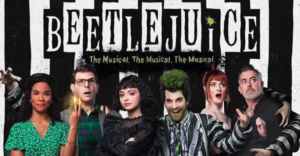 Castmembers of the Beetlejuice touring company are lined up under the black and white logo for the production.