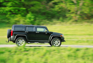 Humvee speeds down country road.