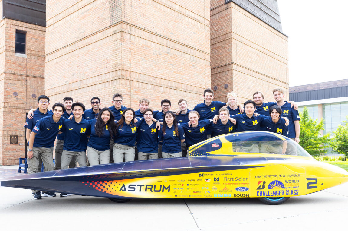 Photo of the U-M Solar Car Team’s race crew with its 2023 vehicle, Astrum, on North Campus.