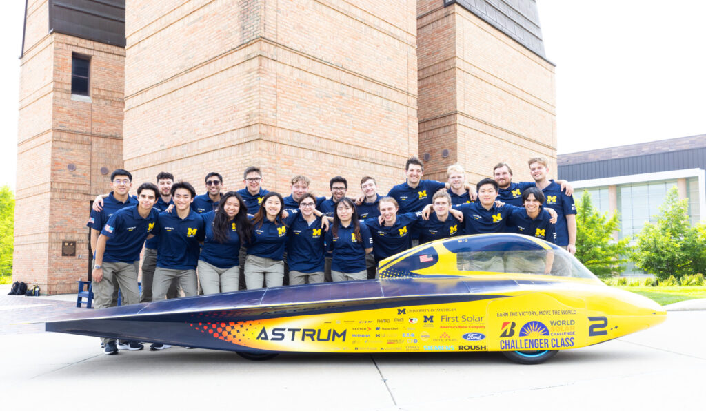 The entire Michigan Solar Car race crew with its 2023 vehicle, Astrum, on the University of Michigan's North Campus in Ann Arbor, MI.