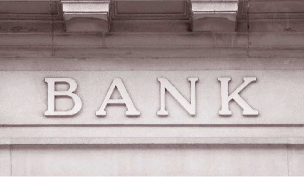 Exterior building sign reading "BANK". Image courtesy: Poverty Solutions