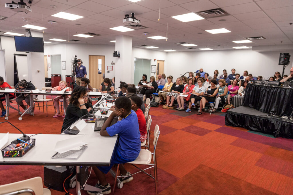 Observers watch as TeachingWorks Deborah Lowenberg Ball interacts with a fifth-grade student in the 2017 EML. Image credit: Brian Powers