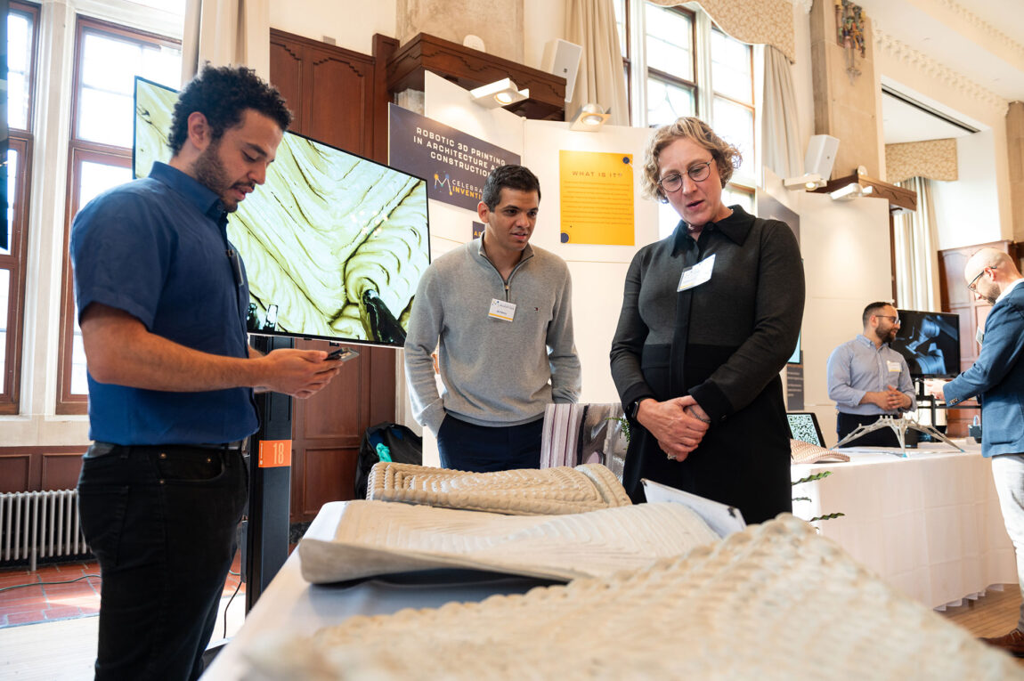 Photo fo graduate students Abdallah Kamhawi and Ali Fahmy discussing 3D-printed concrete with Rebecca Cunningham.
