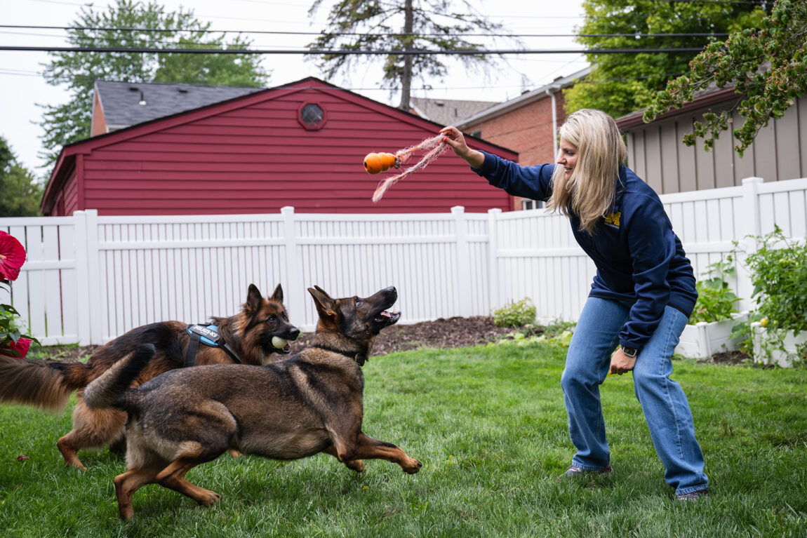 A photo of Casandra Ulbrich playing with her two dogs