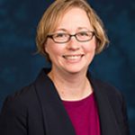 Blonde, caucasian woman with glasses.