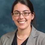 Headshot of woman with dark hair and glasses.