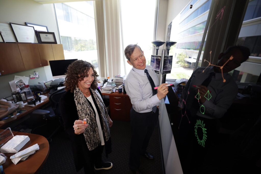 Sharon Glotzer and Nicholas Kotov drawing particle arrangements on the blackboard in Glotzer’s office. Image credit: Brenda Ahearn, Michigan Engineering