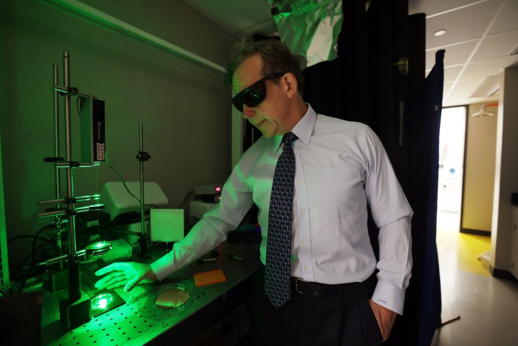 Nicholas Kotov places a plastic substrate for 3D printing of twisted nanopillars from silver in the Kotov Lab. Image credit: Brenda Ahearn, Michigan Engineering