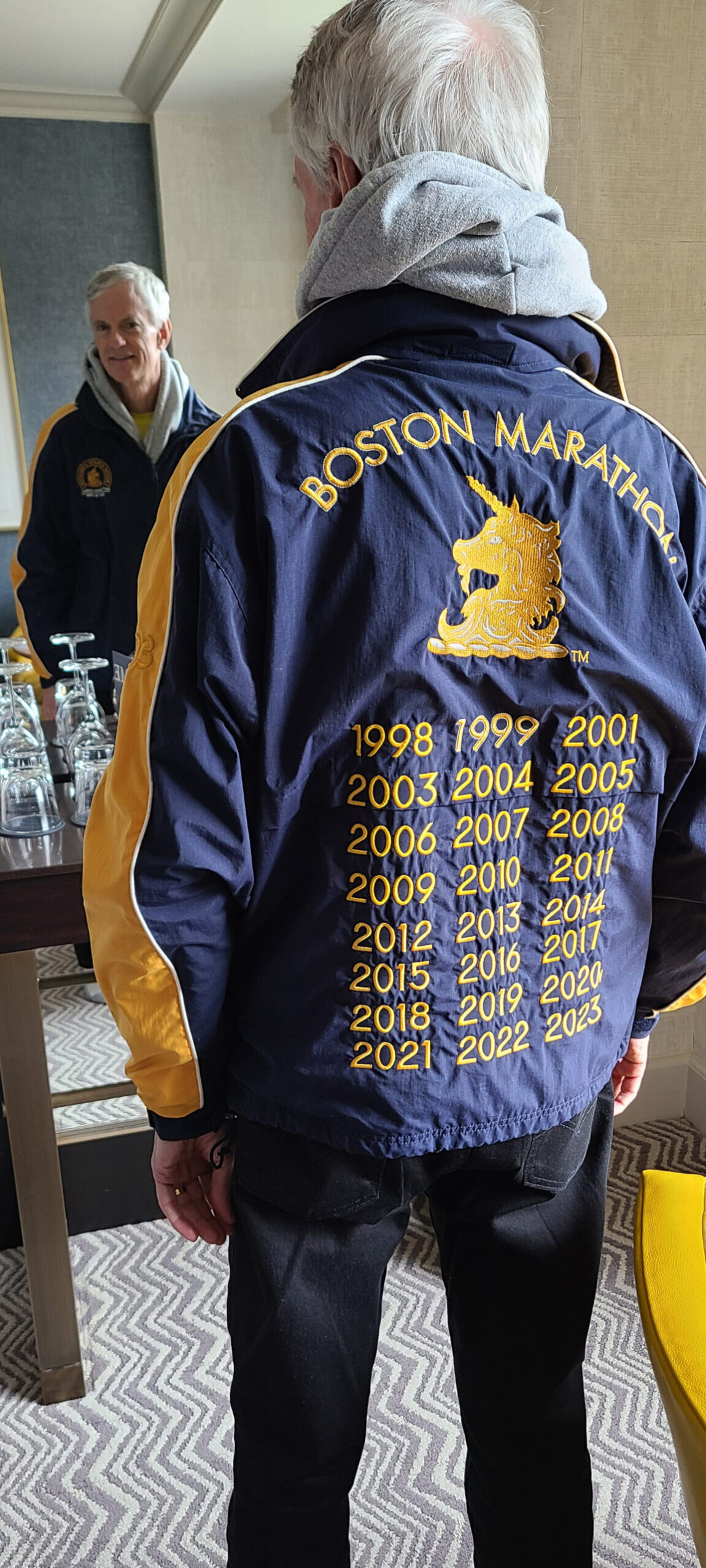 A photo of Chris Roberts in a jacket showing the years he's run in the Boston Marathon