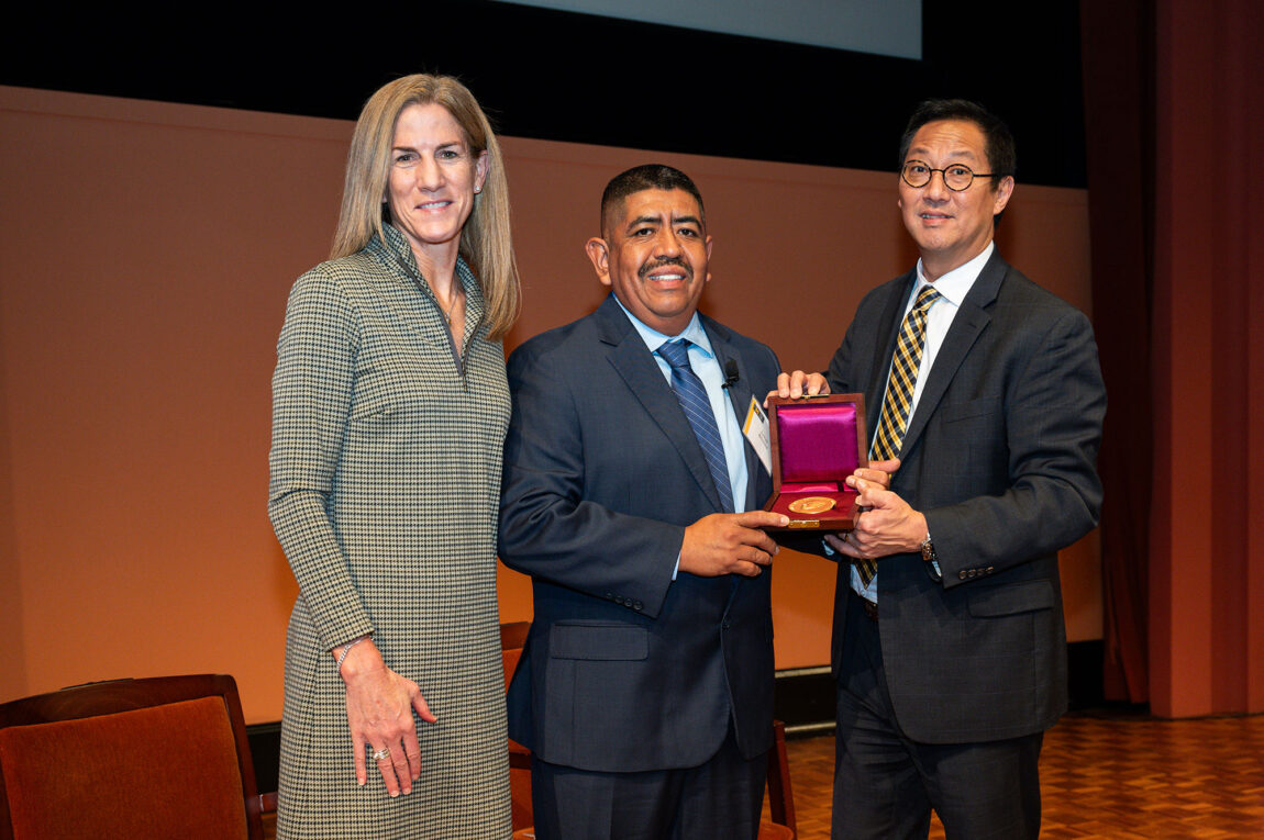 Photo of LSA Dean Anne Curzan and President Santa J. Ono presenting the Wallenberg Medal to Lucas Benitez.