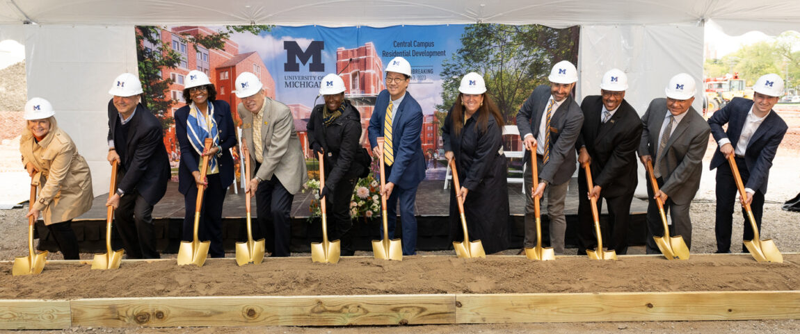 Photo of 11 people turning ceremonial shovelfuls of soil.