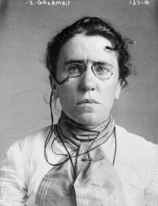 Emma Goldman, circa 1901, mugshot. Black and white image of woman with spectacles.