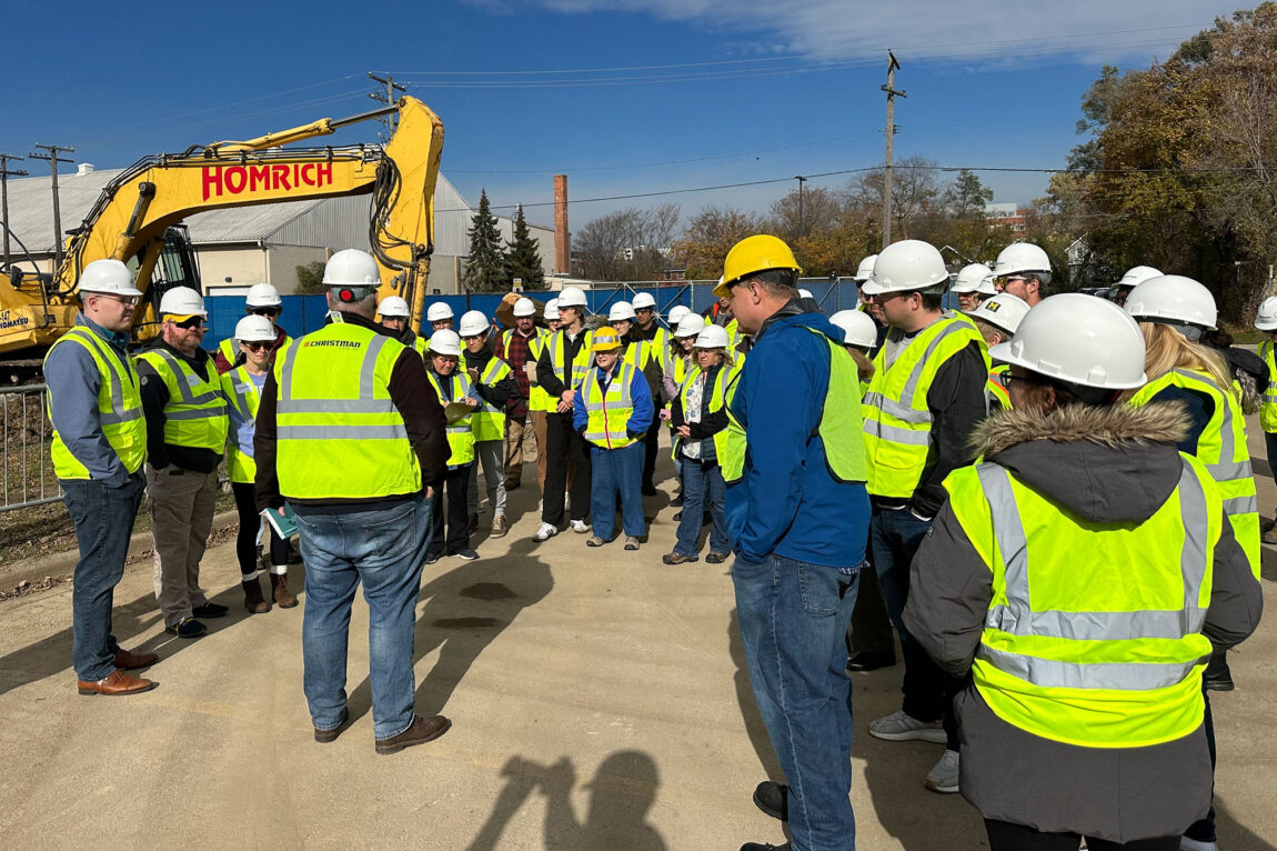 Photo of U-M community members viewing geo-exchange drilling efforts on Nov. 3 at the future site of the Central Campus residential complex.