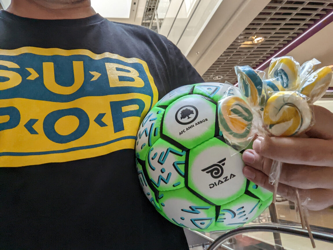 Mike Lorenc holds a soccer ball and lollipops