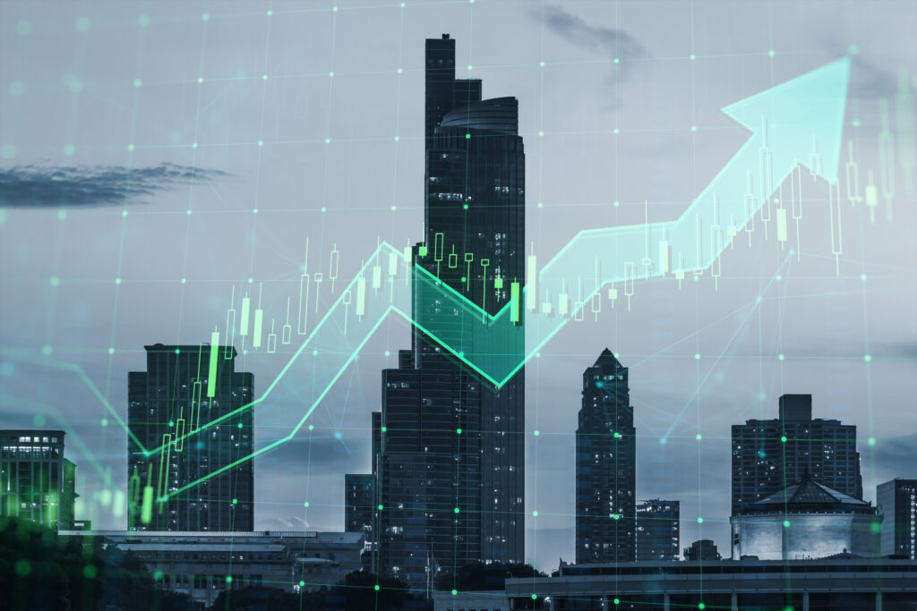 Abstract growing green candlestick arrow on blurry city background. Image credit: iStock