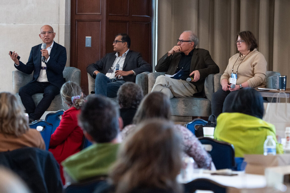 Photo of four people on stage conducting a panel discussion
