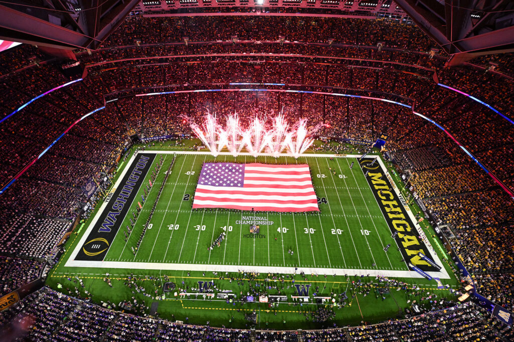 Photo of a large American flag unfurled on the field during championship game's national anthem.