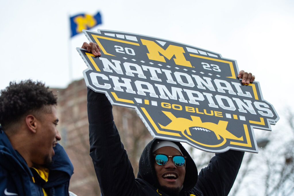Football team members celebrated from parade vehicles.