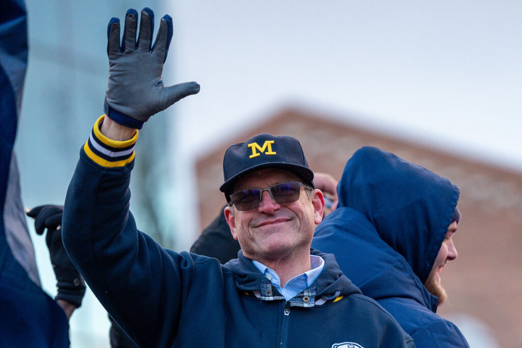 Coach Jim Harbaugh waves to the crowd. 