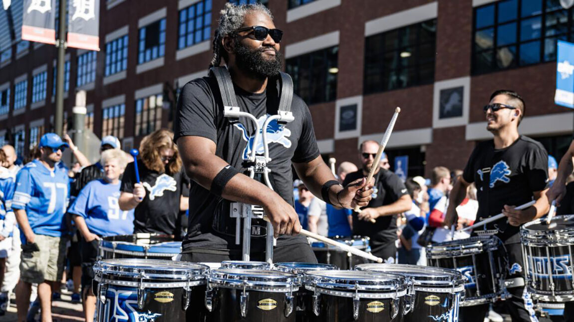 A photo of a man playing the drums before a Detroit Lions game.
