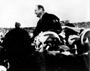 Black & white image of Bo Schembechler on players' shoulders after victory at OSU in 1969.
