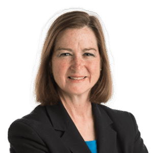 Headshot of caucasian woman in business clothes. Shoulder-length brown hair, freckles, and a smile.