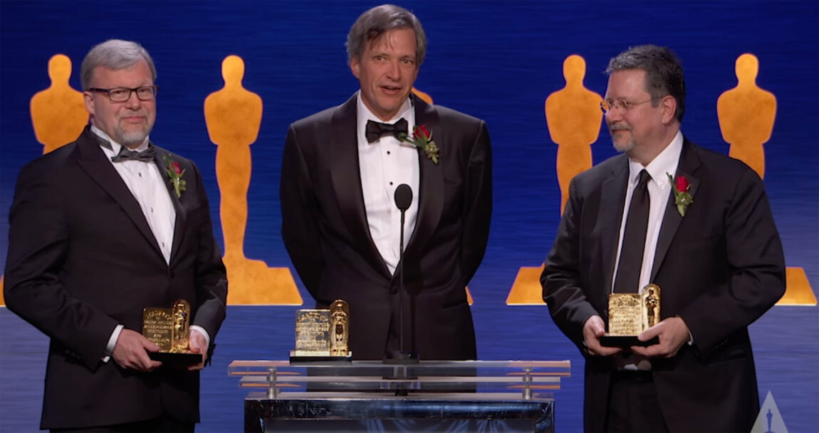 A photo of three men holding Academy Awards