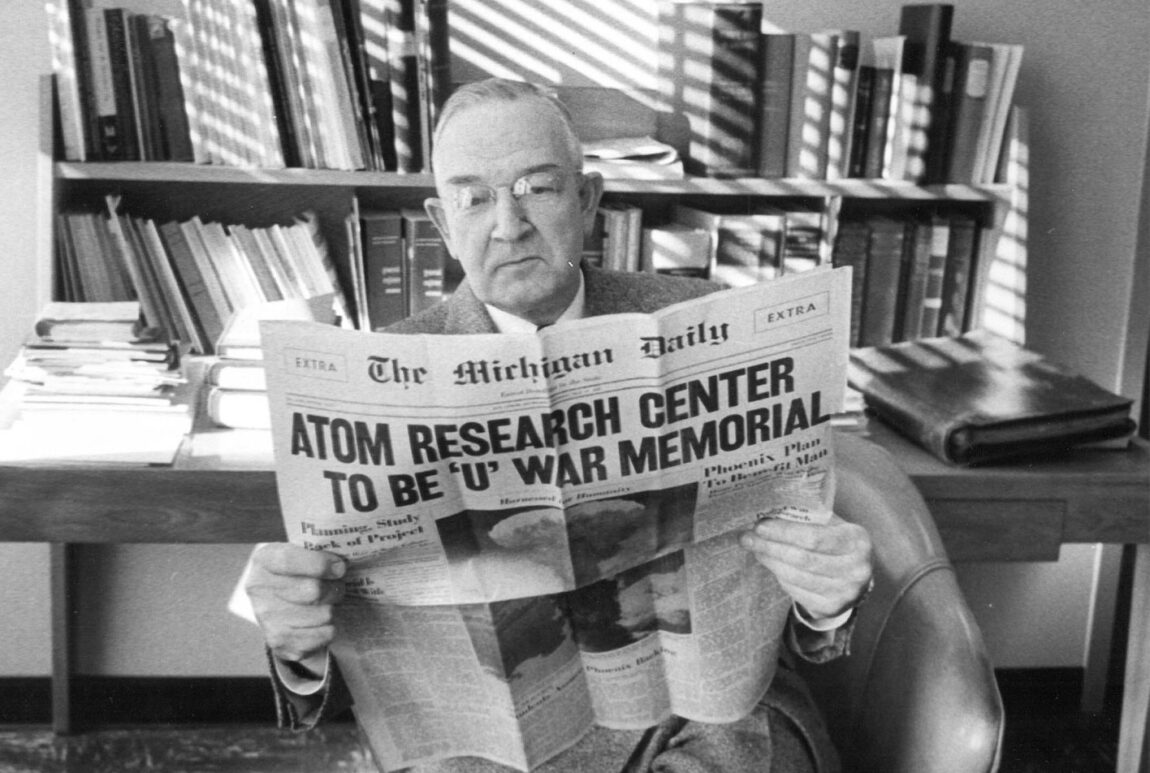 A photo of a man reading an old edition of the Michigan Daily